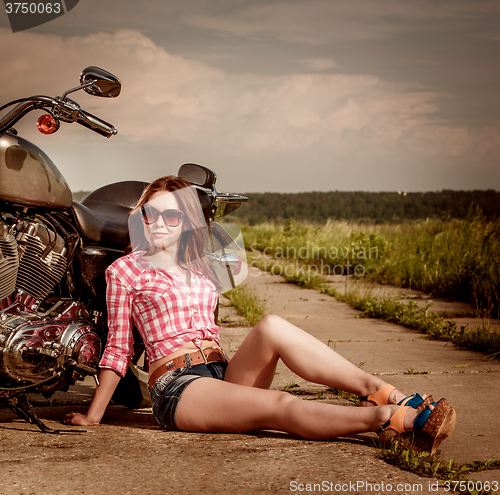 Image of Biker girl sitting on motorcycle