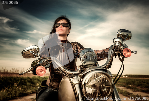 Image of Biker girl sitting on motorcycle