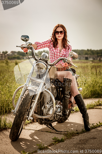 Image of Biker girl sitting on motorcycle