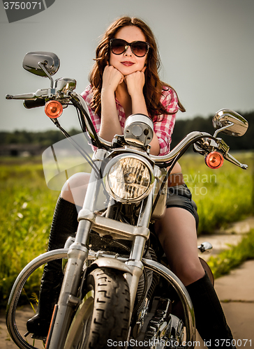 Image of Biker girl sitting on motorcycle