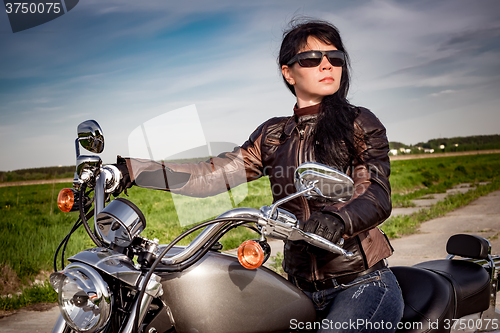 Image of Biker girl sitting on motorcycle