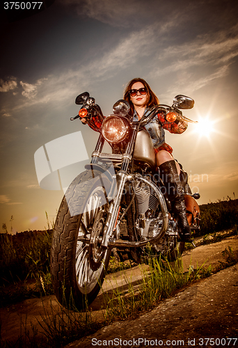 Image of Biker girl sitting on motorcycle