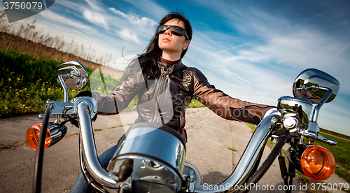 Image of Biker girl sitting on motorcycle