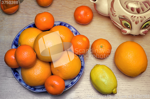 Image of Oranges and tangerines in a beautiful ceramic vase.