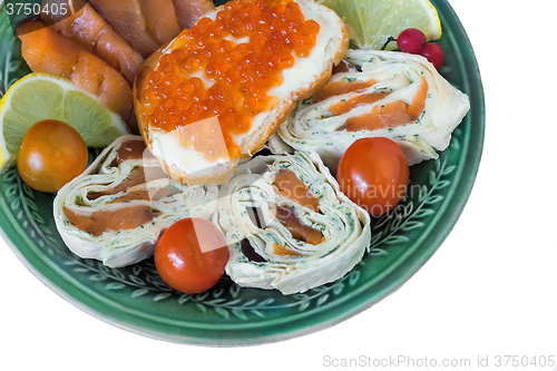 Image of Baked fish and vegetables on plate on white background.