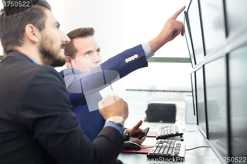 Image of Stock traders looking at computer screens.