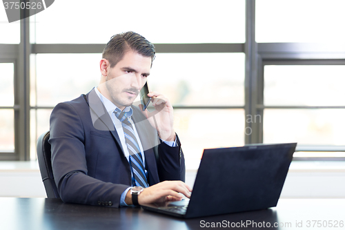 Image of Businessman in office working on laptop computer.