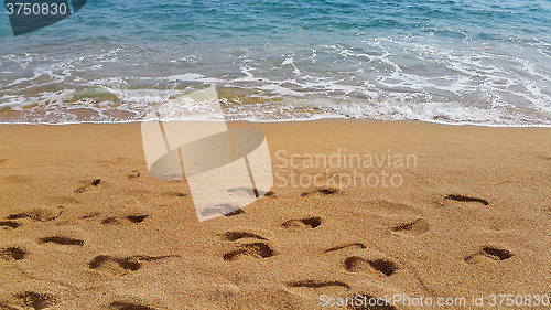 Image of Waves and footprints on the sand beach