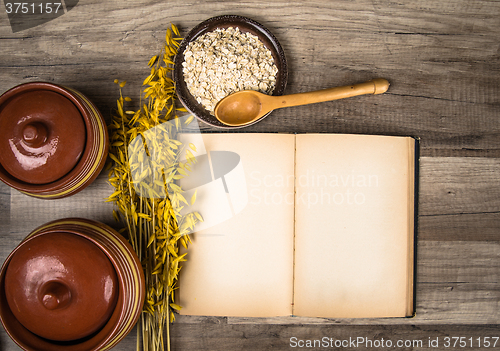 Image of The top view on the opened cookbook and kitchen utensils