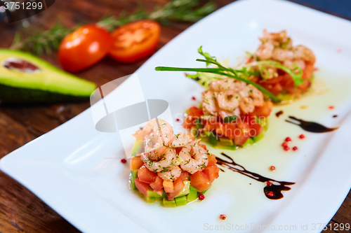 Image of Salad with shrimps, tomato and avocado.