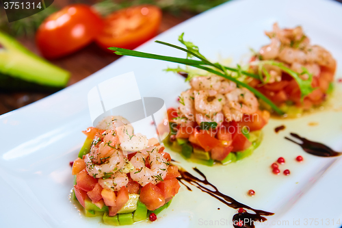 Image of Salad with shrimps, tomato and avocado.