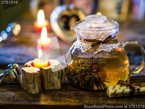 Image of exotic green tea with flowers in glass teapot 