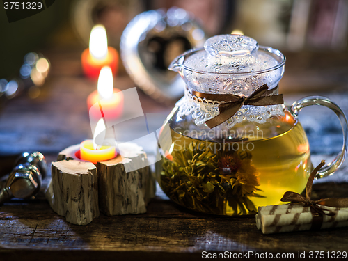 Image of exotic green tea with flowers in glass teapot 