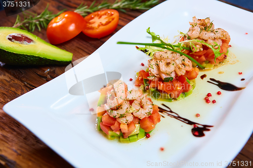 Image of Salad with shrimps, tomato and avocado.