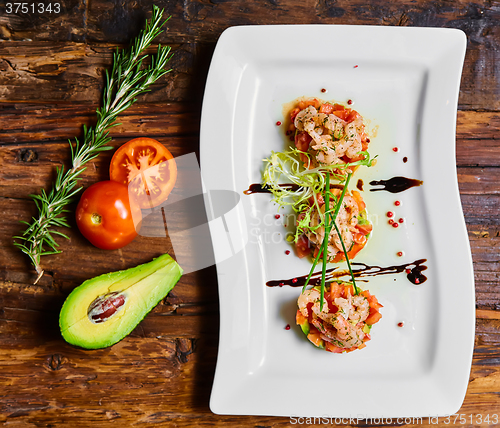 Image of Salad with shrimps, tomato and avocado.