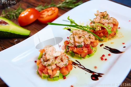 Image of Salad with shrimps, tomato and avocado.