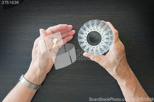 Image of Elderly person taking medication