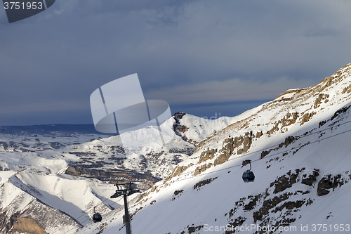 Image of Gondola lift on ski resort at sun evening