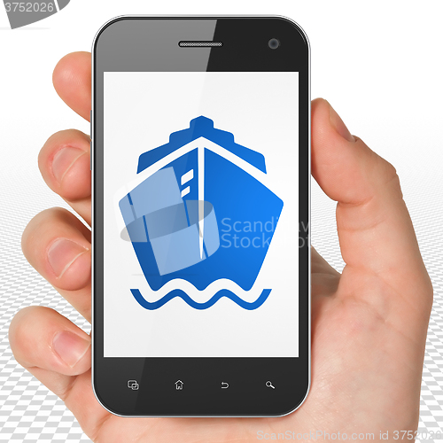 Image of Vacation concept: Hand Holding Smartphone with Ship on display
