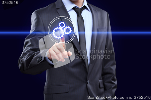 Image of business, technology and internet concept - businessman pressing button with mechanism icon on virtual screens