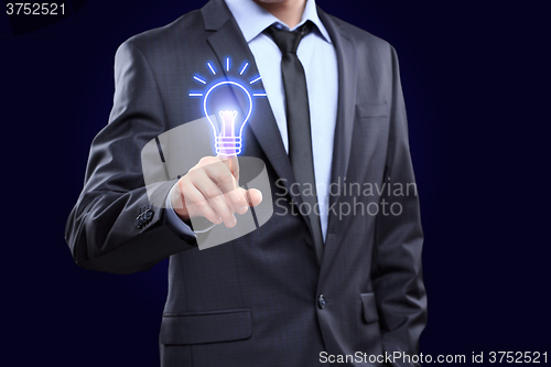 Image of business, technology concept - businessman pressing button with bulb on virtual screens