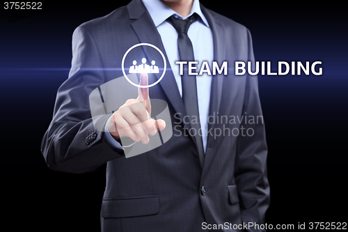 Image of Businessman pressing button on touch screen interface and select Team building. Business, technology concept.