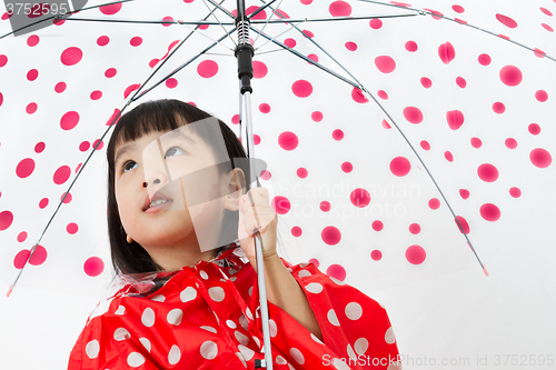 Image of Chinese Little Girl Holding umbrella with raincoat