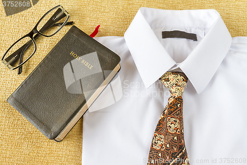 Image of business man style clothes and Holy Bible at home