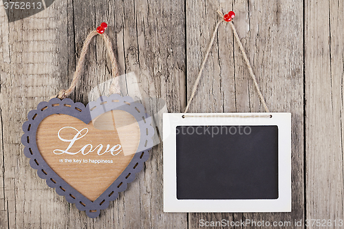 Image of Empty wooden blackboard sign and heart shape frame 