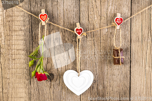 Image of Red rose with white shape heart and chocolate on wooden