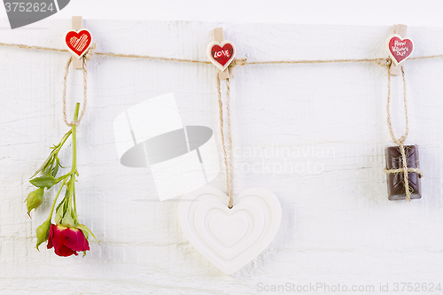 Image of Red rose with white shape heart and chocolate on white