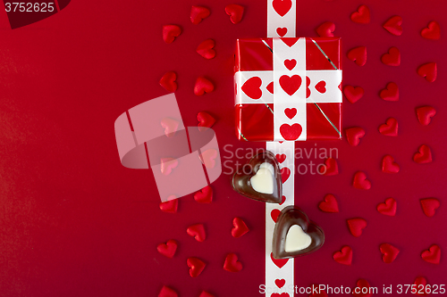 Image of Gift and chocolate and red hearts on red