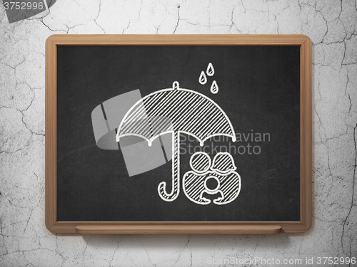 Image of Protection concept: Family And Umbrella on chalkboard background