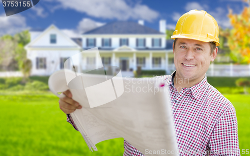 Image of Contractor Holding Blueprints In Front of  Beautiful Custom Home