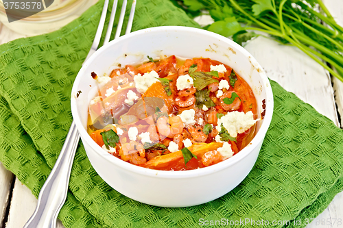 Image of Shrimp and tomatoes with feta in white bowl on napkin