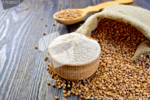 Image of Flour buckwheat in bowl and spoon with cereals on board