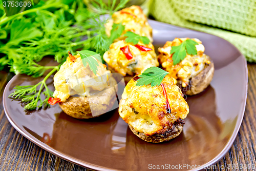 Image of Champignons stuffed meat in brown plate on dark board