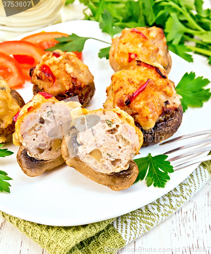 Image of Champignons stuffed meat cut in white plate on napkin