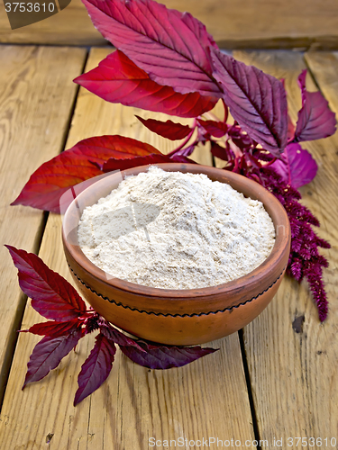 Image of Flour amaranth in clay bowl on board with purple flower