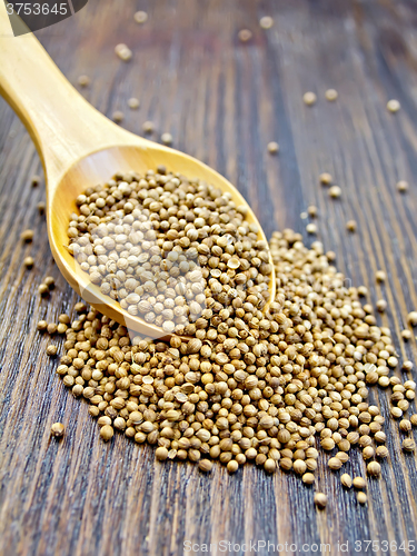 Image of Coriander seeds in spoon on board