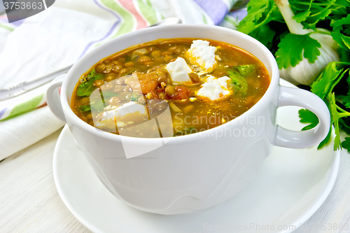 Image of Soup lentil with spinach and feta in white cup on board