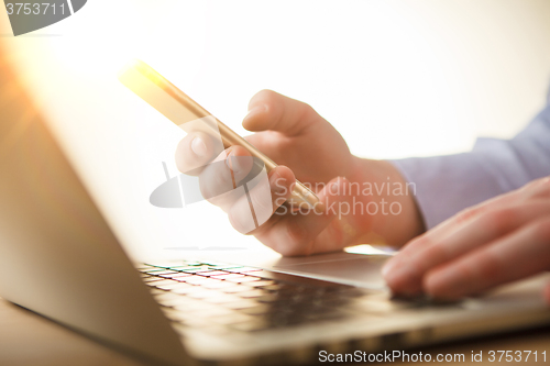 Image of The male hand holding a phone 