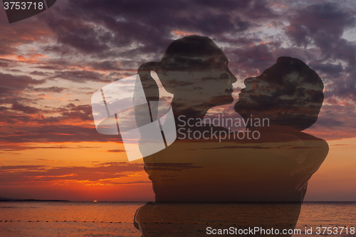 Image of Romantic couple on the beach at colorful sunset 
