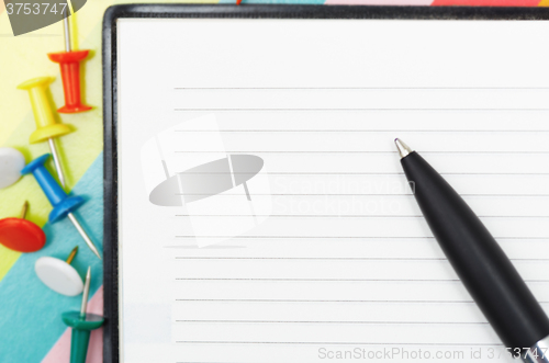 Image of Notepad with pen and pushpins