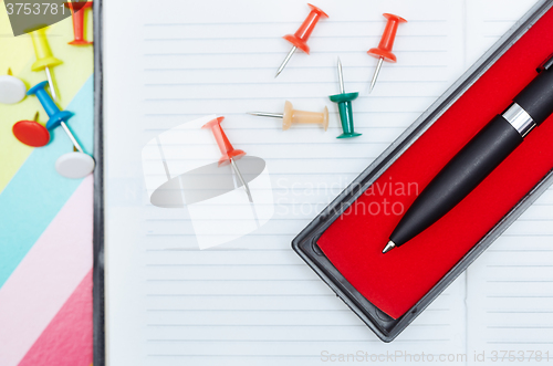 Image of Notepad with pen and pushpins