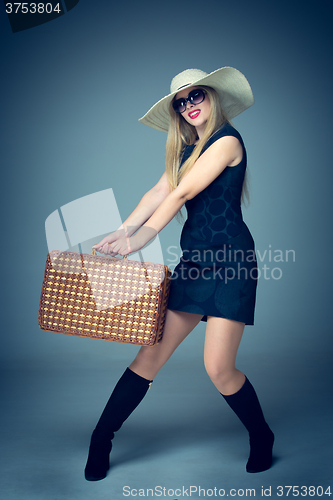 Image of The traveler woman standing with retro suitcase 