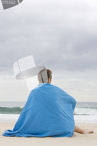 Image of woman with blue blanket on beach