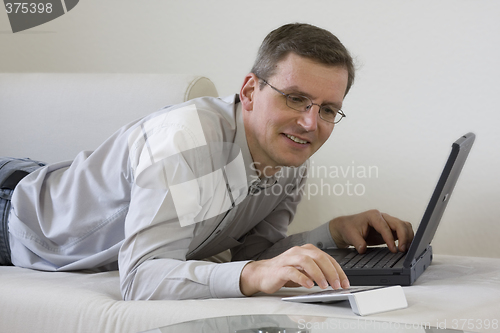 Image of Man on coach with laptop computer