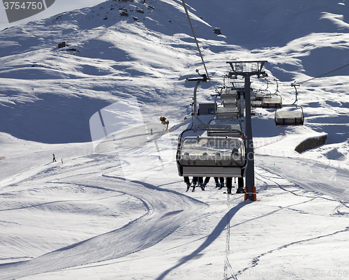 Image of Chair-lift and ski slope at sun evening