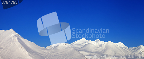 Image of Panoramic view of snowy mountains and blue clear sky